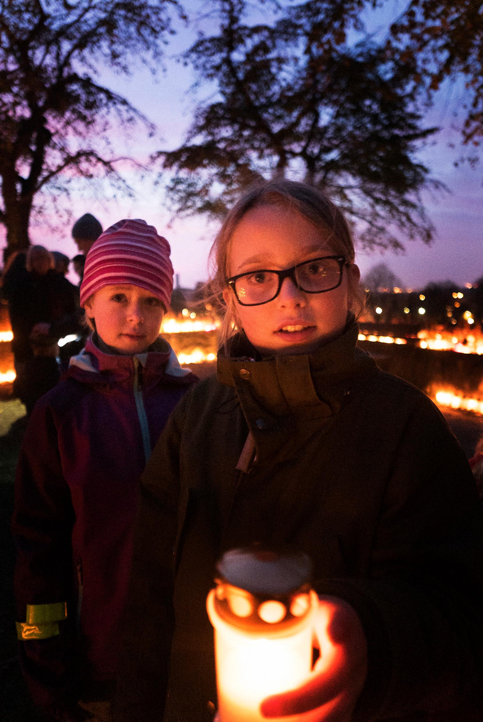 дети с горящими свечами в День Всех Святых