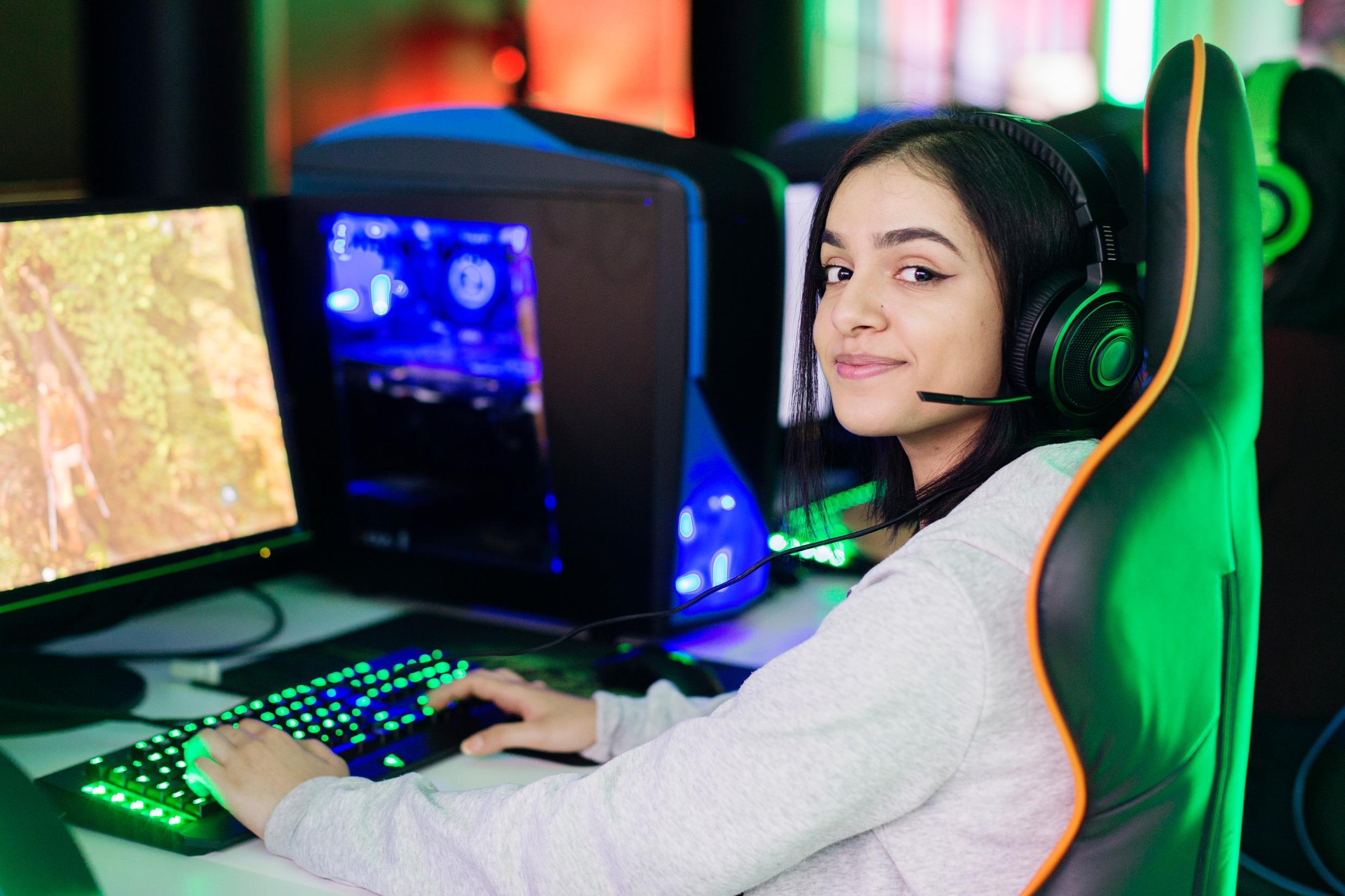 Девушка за компьютером, играющая в видеоигру.